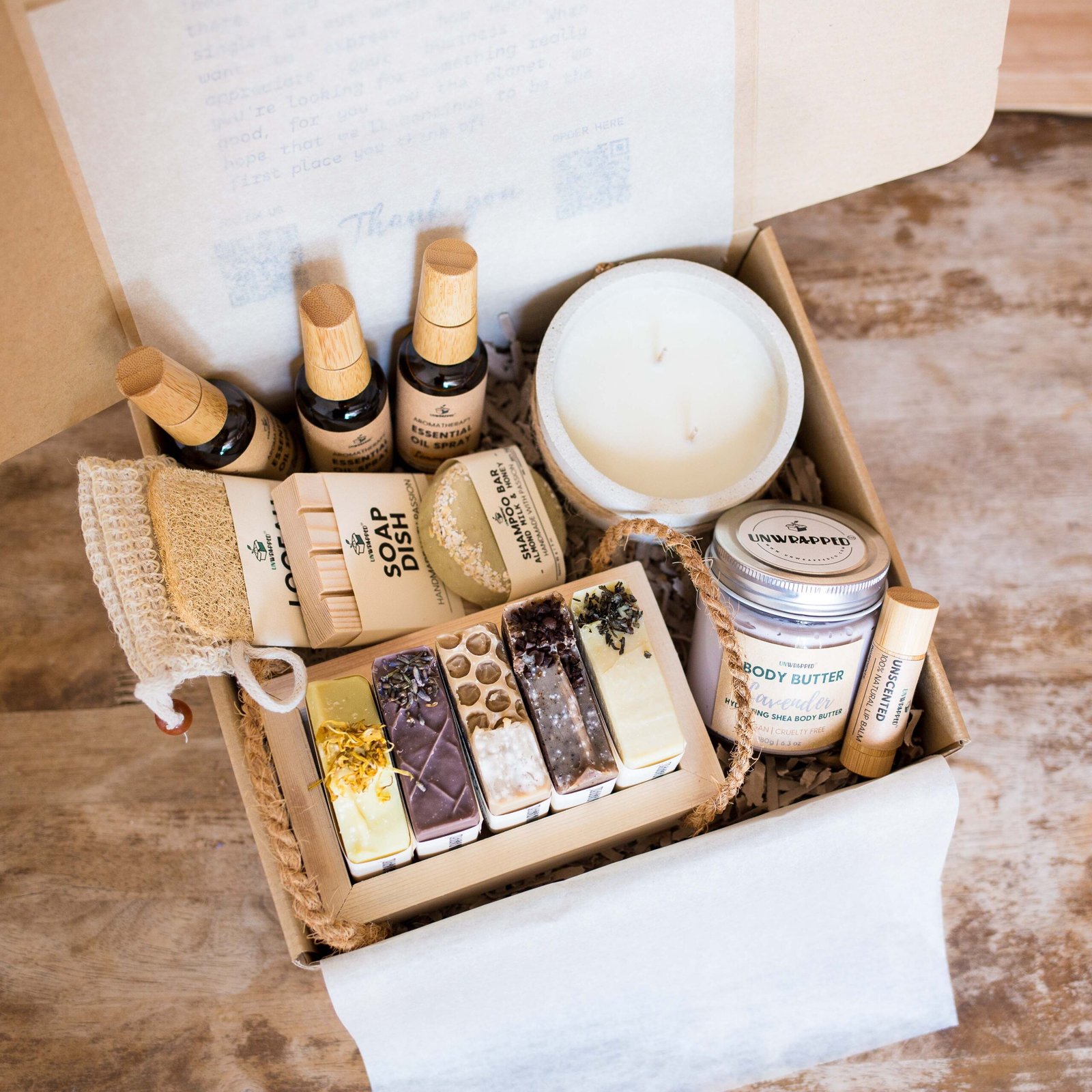 Unwrapped ultimate luxury gift set with essential oil sprays, soap bag, loofah, soap dish, shampoo bar, large candle, whipped body butter, lip balm and five soap bars